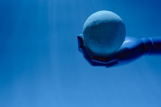 A robotic hand holds a glowing celestial sphere against a blue background, evoking a futuristic theme.